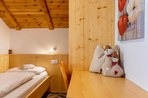 a bedroom with a bed and a wooden table at Malsötscherhof Apt C in Villandro