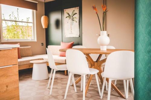 Il comprend une cuisine et une salle à manger avec une table et des chaises blanches. dans l'établissement Camping Le Braou - Maeva, à Audenge