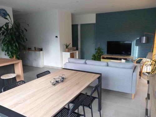 a living room with a table and a couch at Maison de la croix Marion in Chinon