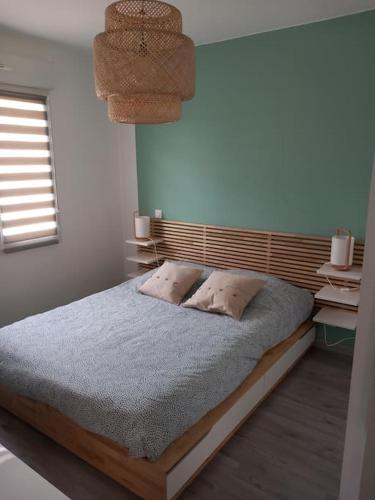 une chambre avec un lit avec une tête de lit en bois dans l'établissement Maison de la croix Marion, à Chinon