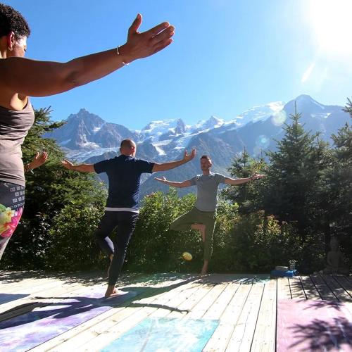 a group of people doing yoga in the mountains at Chalet Serena - luxury 7 Bedroom Chalet, Pool & Spa in Les Houches