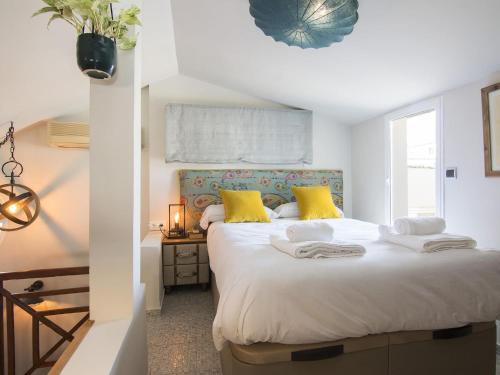 ein Schlafzimmer mit einem großen weißen Bett mit gelben Kissen in der Unterkunft Cathedral Cozy Penthouse in Granada