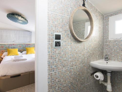 ein Bad mit einem Bett, einem Spiegel und einem Waschbecken in der Unterkunft Cathedral Cozy Penthouse in Granada