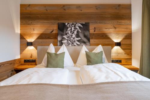 a bedroom with a bed with white sheets and pillows at Chalet Edelweiss in Niedernsill