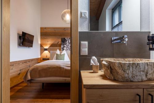 a bathroom with a large stone sink next to a bed at Chalet Edelweiss in Niedernsill