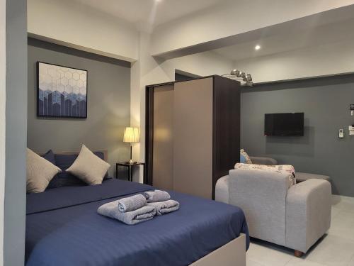 um quarto com uma cama azul e uma cadeira em Modern Studio in the Centre of Chiang Mai em Chiang Mai