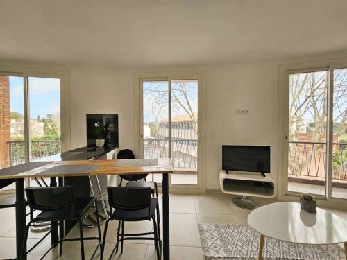 un salon avec une table, des chaises et une télévision dans l'établissement A deux pas du centre Historique, à Fréjus