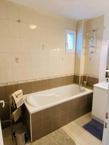 une salle de bain avec une baignoire et une fenêtre dans l'établissement Appartement très lumineux au cœur du massif de la Sainte Baume, à Plan dʼAups