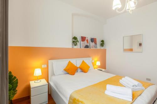 ミラノにある"Suite Elegance Brera"のベッドルーム1室(オレンジ色のアクセントが効いた白いベッド1台付)