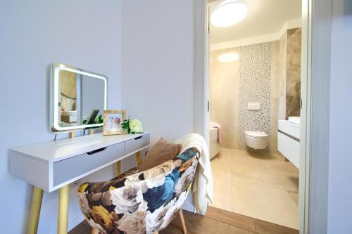 a bathroom with a sink and a mirror and a chair at Villa Andante in Krk