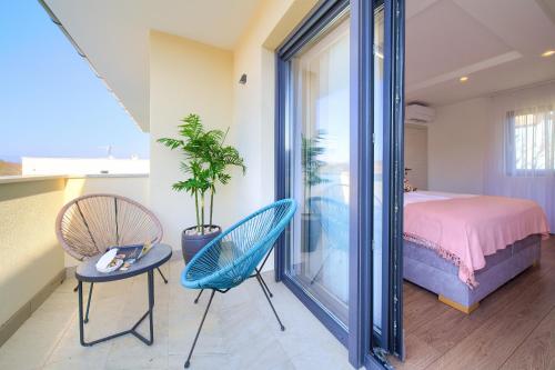 a bedroom with a bed and two chairs and a table at Villa Andante in Krk