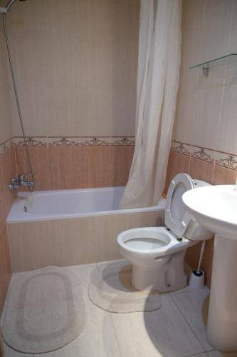 a bathroom with a toilet and a sink and a tub at Oliva Mar in Lloret de Mar