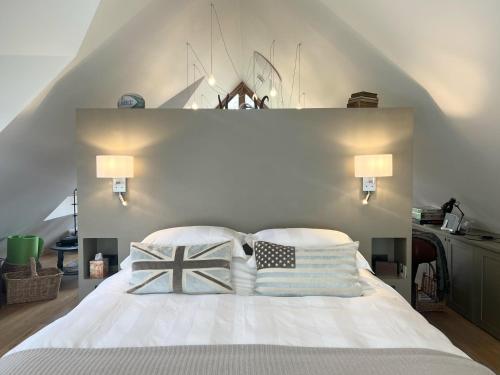 a bedroom with a white bed with pillows on it at Luxurious Oak Barn in Cotswold Countryside in Shipston-on-Stour
