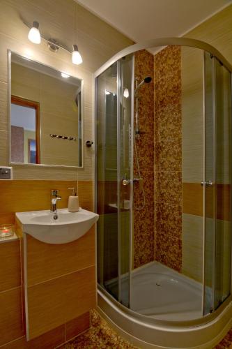 a bathroom with a glass shower and a sink at Dom Wczasowy Na Szczycie in Zakopane