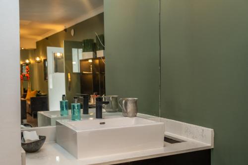 a bathroom with a white sink and a mirror at Croft Court Hotel in London