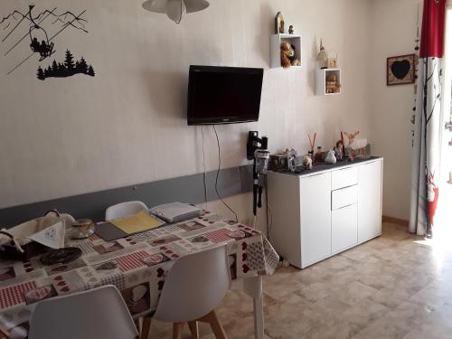 una sala da pranzo con un tavolo e una TV a parete di Superdévoluy Les Issarts a Superdevoluy