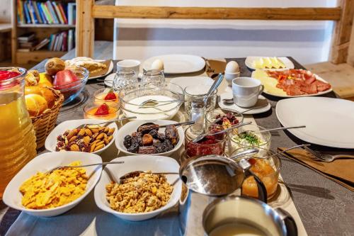 a table topped with plates and bowls of food at Malsötscherhof Apt A in Villandro