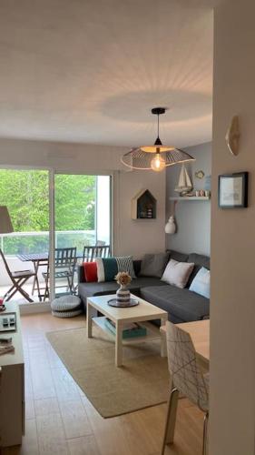 un salon avec un canapé et une table dans l'établissement Appartement cosy, vue sur parc, 3 mins plage Benoit, à La Baule