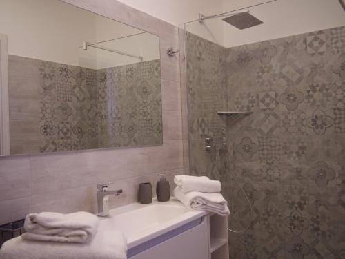 a bathroom with a sink and a shower with a mirror at Our Guest House in Fiumicino