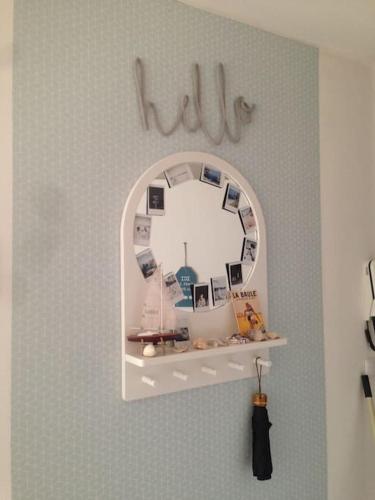 une étagère avec un miroir sur un mur dans l'établissement Appartement cosy, vue sur parc, 3 mins plage Benoit, à La Baule
