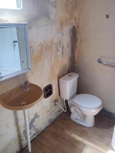 a bathroom with a toilet and a sink at Casa Centro Parajuru in Parajuru