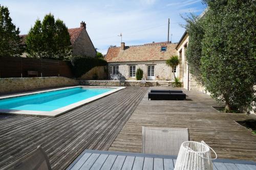 une cour arrière avec une piscine et une maison dans l'établissement LE MOULIN DE TANQUEUX, à Cerny