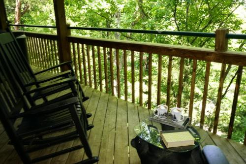 a rocking chair and a book on a deck at Lazy Bear Den in Sevierville