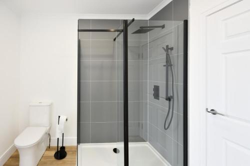 a shower with a glass door in a bathroom at Troon Portland Apt B in Troon