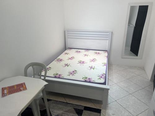 Bett in einem Zimmer mit einem Tisch und einem Spiegel in der Unterkunft Suite 1, Casa Amarela, Segundo Andar in Nova Iguaçu