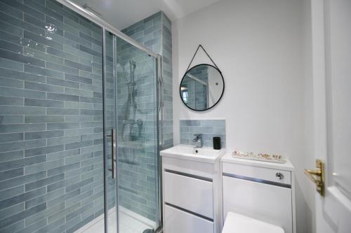 W łazience znajduje się prysznic, umywalka i lustro. w obiekcie Dunvegan Apartment Troon w mieście Troon
