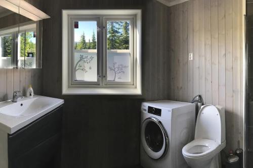 a bathroom with a washing machine and a sink at Modern cottage at Nordseter/Sjusjøen/Lillehammer in Lillehammer
