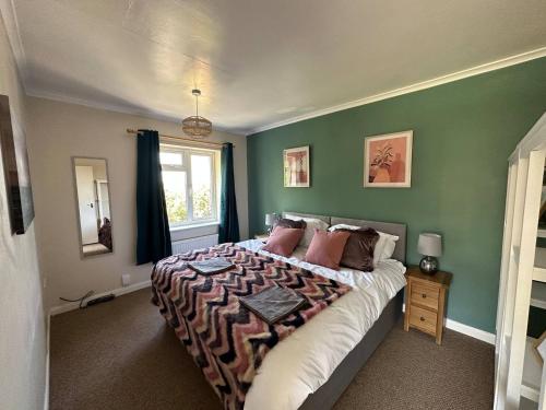 a bedroom with a large bed with green walls at Comfortable 3 Bed Perfect For Contractors in Lincolnshire