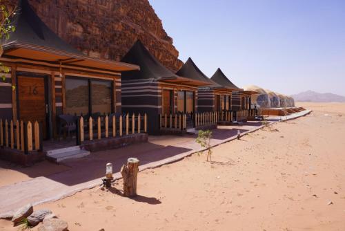 a row of wooden buildings in the desert at Shaheen Camp Wadi rum in Wadi Rum
