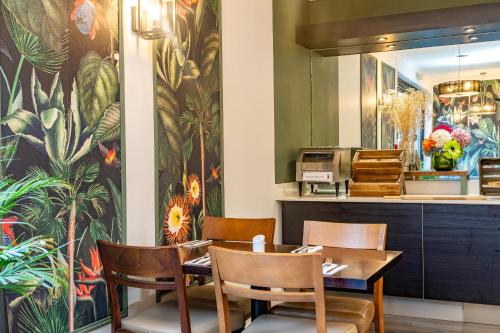 a restaurant with a table and chairs and a wall mural at Croft Court Hotel in London