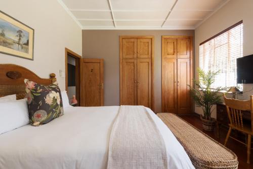 a bedroom with a bed and a desk and a television at House Falcon close to ZAH in Pretoria