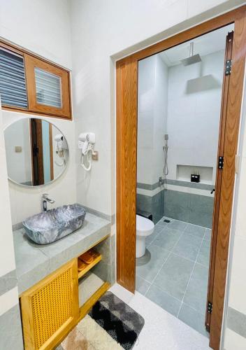 a bathroom with a sink and a toilet and a mirror at HOLIDAY HOTEL PHAN THiẾT in Ấp Bình Hưng