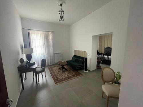 uma sala de estar com um sofá verde e cadeiras em Borgo Scorciarini B&B em Piedimonte dʼAlife