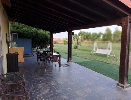 un patio con mesa, sillas y gol en Il giardino di Ercole, en San Pietro Vernotico