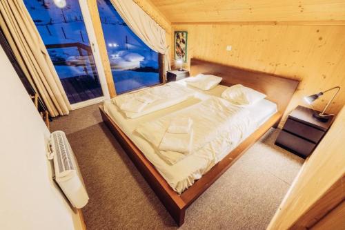 a large bed in a room with a window at Woody Park Chalet 14 in Kaindorf