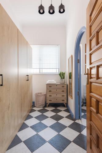 a hallway with a checkered floor and a wooden door at House Falcon close to ZAH in Pretoria