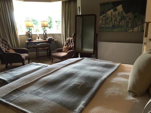 a bedroom with a bed and a desk and a window at Fauhope Country House in Melrose