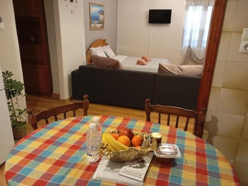 a table with a bowl of fruit and a bed at Margaritas Cottage in Nafplio