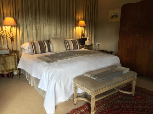 a bedroom with a large white bed and a table at Fauhope Country House in Melrose