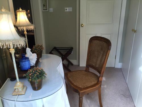 a room with a table with a lamp and a chair at Fauhope Country House in Melrose
