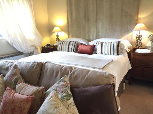 a bedroom with a bed and a couch with pillows at Fauhope Country House in Melrose