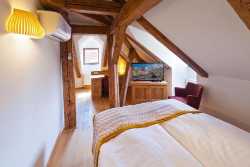 sypialnia z łóżkiem w pokoju z drewnianym sufitem w obiekcie Havelska Old Town Residence w Pradze
