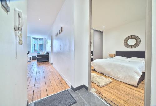 une chambre avec un lit et une horloge au mur dans l'établissement UnSejourAMetz - Les douillets, du T2 au T3, hyper-centre, à Metz