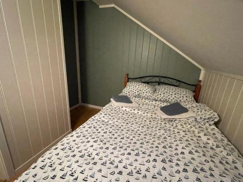 a bedroom with a bed with a black and white comforter at Bakkebo Trollstigen in Åndalsnes