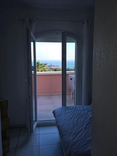 Villa Perle d'or vue mer في سانت رافائيل: غرفة نوم مع باب زجاجي منزلق للشرفة