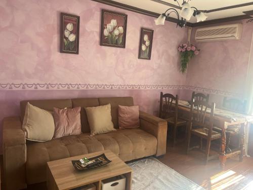 ein Wohnzimmer mit einem Sofa und einem Tisch in der Unterkunft Retiro del emperador in Cuacos de Yuste